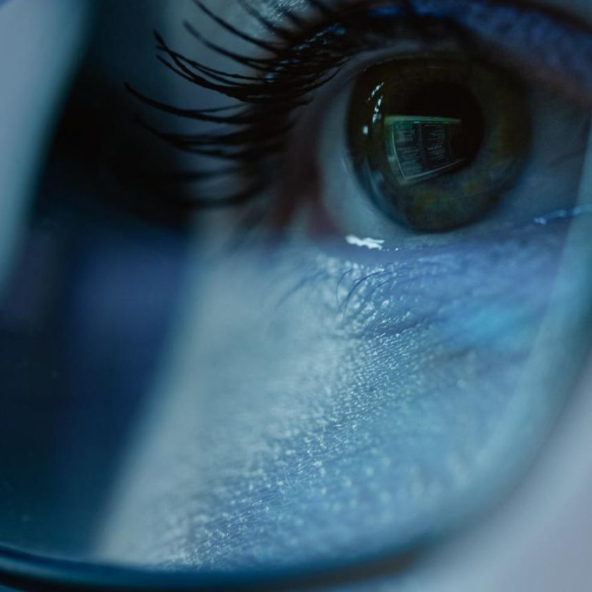 close up of a woman's eye with glasses on her face